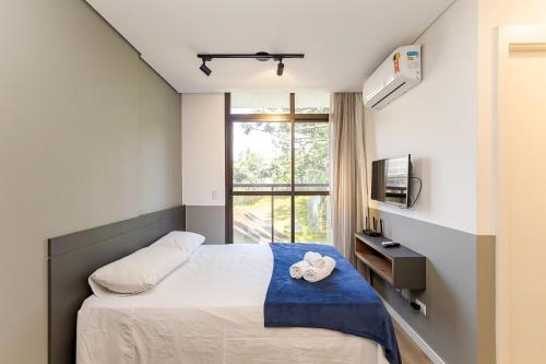 a bedroom with a bed and a window at Eco Smart - Ecoville | Gonzaga Stays in Curitiba