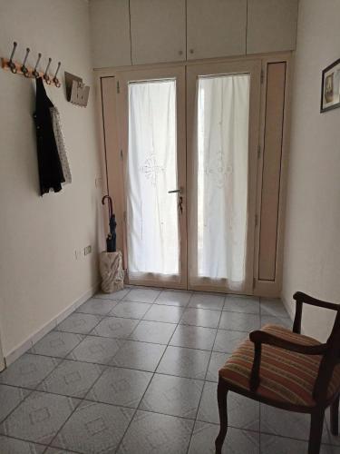 a room with a door and a chair and a tiled floor at Casa Canale in Gesualdo