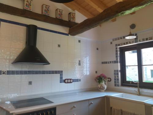 a kitchen with a stove top oven next to a sink at Casona De Linares in Selaya