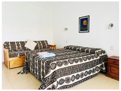 LA ESQUINA DE LA FLOR في Campo Quijano: غرفة نوم بها سريرين وأريكة