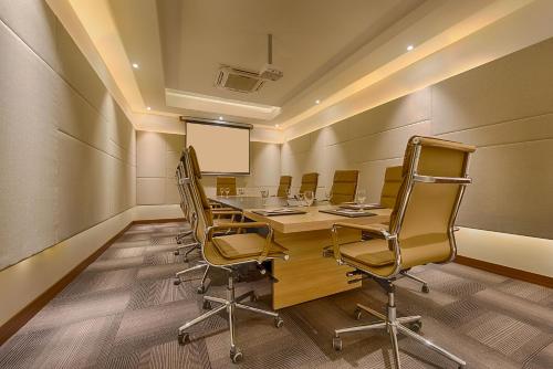 a conference room with a long table and chairs at Kiscol Grands Hotel in Coimbatore