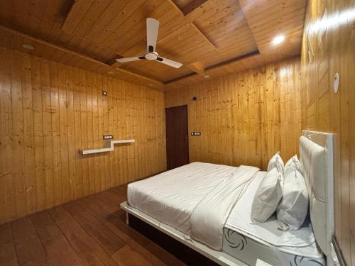 Wood Luxury Hotels Kasauli في كاساولى: غرفة نوم بجدران خشبية وسرير بسقف