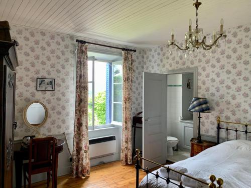 a bedroom with a bed and a window and a mirror at Les Chambres de la Closerie in Saint-Didier-sur-Rochefort