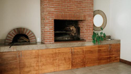 a living room with a brick fireplace and a mirror at 13 Olives, Entire Grape & Olive Estate, Somerset West by Euphoric Leisure in Sir Lowryʼs Pass