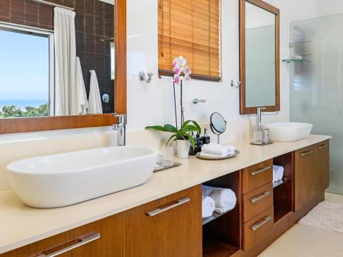 ein Badezimmer mit großem Waschbecken und Spiegel in der Unterkunft 11 On Fairway Villa by Euphoric Leisure in Southbroom