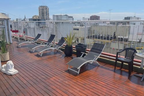 una fila de sillas sentadas en una cubierta en San Remo Grand Hotel, en Mar del Plata