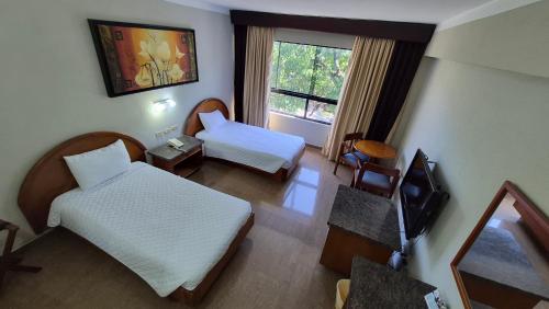 a hotel room with two beds and a television at Hotel Emperador VENEZUELA in Valencia
