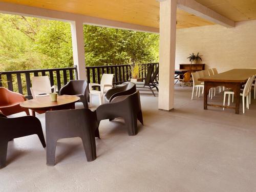 a patio with tables and chairs on a balcony at Gîtes et yourte le Tucaou avec bains nordiques in Camous