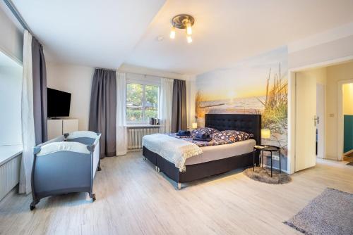 a bedroom with a bed and a chair in it at Ferienhaus Sandstrand in Timmendorfer Strand