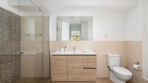 Un baño con inodoro, lavabo y ducha. en Salt and Serenity - Lux Home With Heated Pool, en Anna Bay