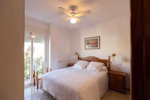 a bedroom with a bed and a ceiling fan at Apartamentos Miguel Angel in Estepona
