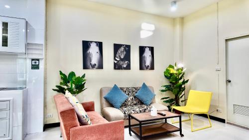 a living room with a couch and chairs at Phra Singh 64 Old City Center Stay in Chiang Mai