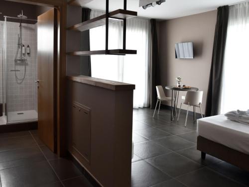 a bedroom with a bathroom with a shower and a table at Domus Natura, un'oasi verde tra Padova e Venezia in Vigonza