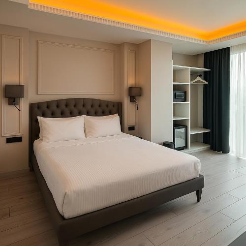 a bedroom with a large bed with an orange ceiling at Loft Airport Hotel in Arnavutköy