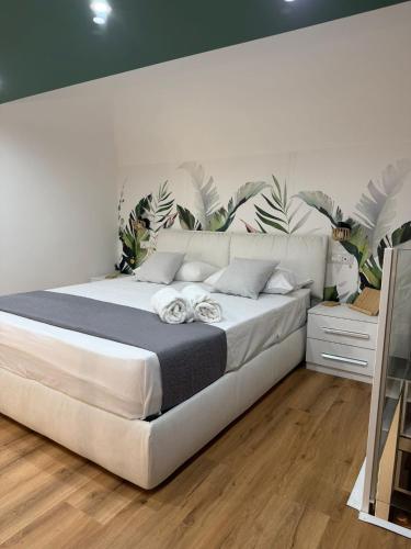 a bedroom with a large white bed with plants on the wall at Figli Di Agata in Catania