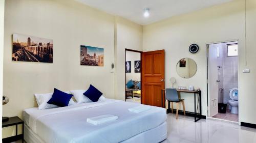 a bedroom with a large white bed and a bathroom at Phra Singh 64 Old City Center Stay in Chiang Mai