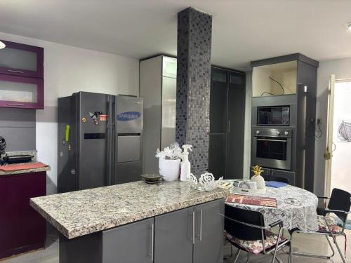 Casa Portada del Sol في La Molina: مطبخ مع أجهزة ستانلس ستيل ومكتب