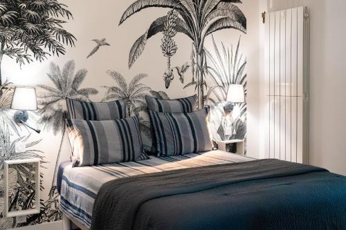 a bedroom with a bed with a mural of palm trees at La Mouline sublime domaine privatif avec piscine à Pézenas in Pézenas