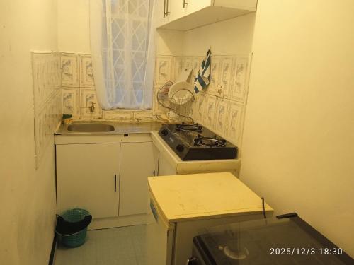 a small kitchen with a stove and a sink at Polycap Cottage Home in Murangʼa
