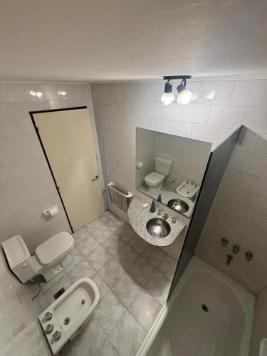 ein Badezimmer mit 2 WCs, einem Waschbecken und einem Spiegel in der Unterkunft Departamento en el centro de Rafaela in Rafaela