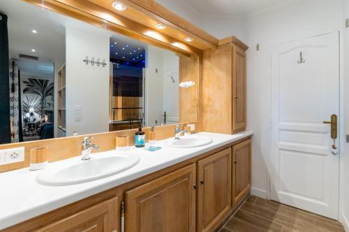 a bathroom with two sinks and a large mirror at La Mouline sublime domaine privatif avec piscine à Pézenas in Pézenas