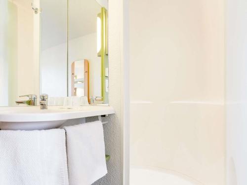 ein Badezimmer mit Waschbecken und Spiegel in der Unterkunft ibis Budget Pau Est in Pau