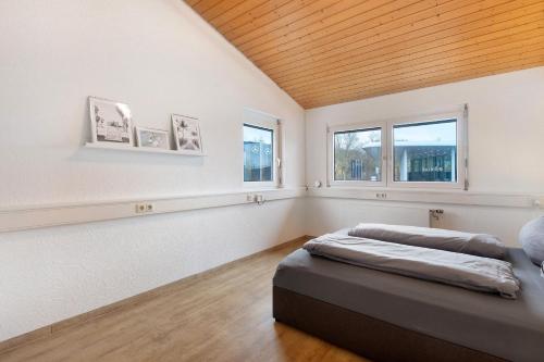 a bedroom with a bed and two windows at Motel Ambiente - 4 Zimmer, 2 Bäder in Bad Säckingen