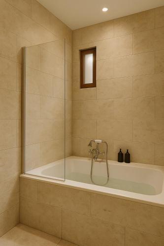 a bathroom with a tub with a glass shower at Hôtel de l'Horloge in Avignon