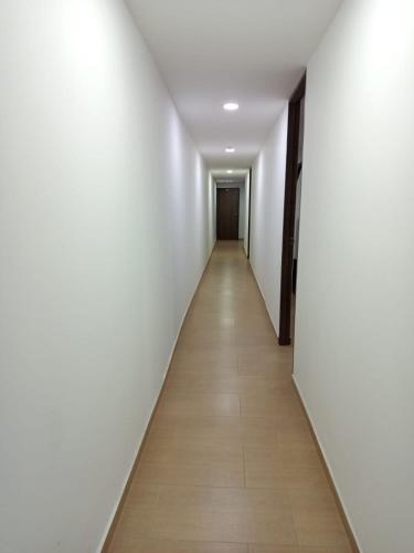 a long corridor with white walls and a wooden floor at Aparta estudio en Álamos in Pasto