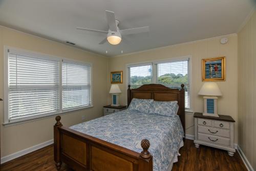 een slaapkamer met een bed en twee dressoirs en ramen bij Beach Blessing in Edisto Island