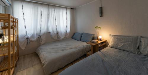 een kleine slaapkamer met twee bedden en een raam bij Sogonhanzip in Seoul