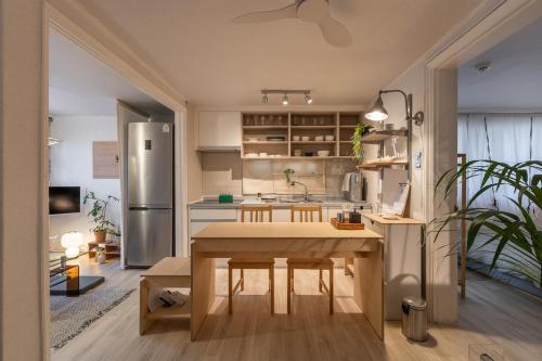 een keuken met een tafel en een roestvrijstalen koelkast bij Sogonhanzip in Seoul
