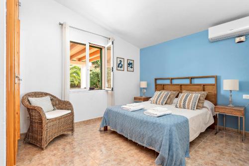 a bedroom with a bed and a chair and a window at Villa Noelia by Escape Home in Santo Tomás
