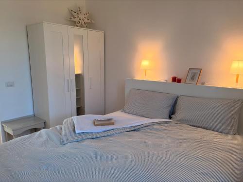 una camera da letto con un letto con un libro sopra di Villa Clara - Comfort e natura nel cuore di Sambuca a Sambuca di Sicilia