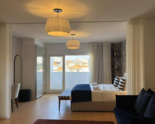 a bedroom with a bed and a couch and two lights at Be Oporto Apartments Clérigos in Porto