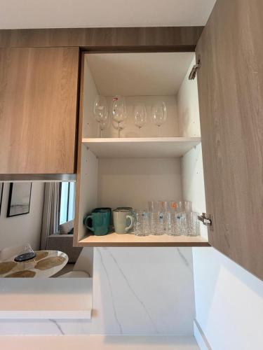 a cupboard with wine glasses and bowls on it at 1BR Yas Golf Collection, short walk to Water Park in Abu Dhabi