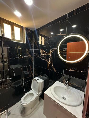 Résidence Diba في داكار: حمام من البلاط الأسود مع مرحاض ومغسلة