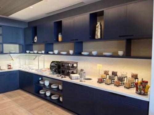 a kitchen with blue cabinets and a counter top at Hyatt Place Toronto Airport in Toronto