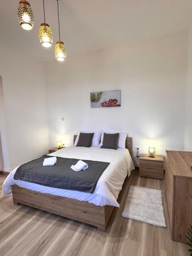 une chambre avec un grand lit avec deux serviettes dessus dans l'établissement Bravas House 1, à Tábua