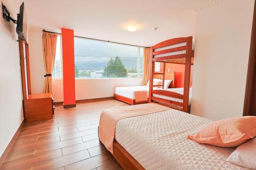 a bedroom with a bunk bed and a large window at Hotel Quitus Airport in Quito