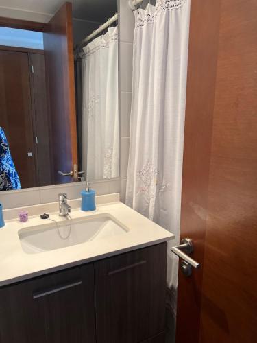 a bathroom with a sink and a mirror and a shower curtain at Viña del Mar Department in Viña del Mar