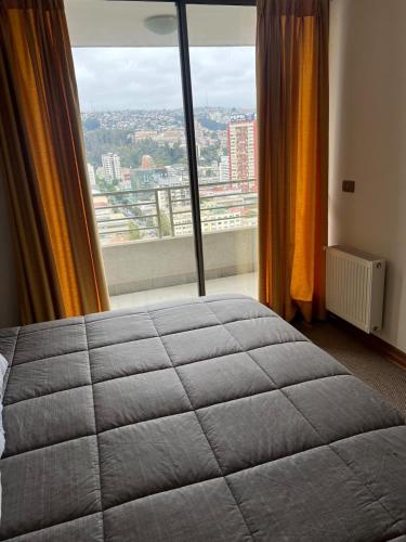 a bedroom with a bed and a large window at Viña del Mar Department in Viña del Mar