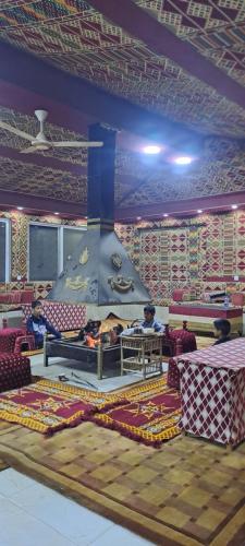 a living room with a large fireplace in a room at Taj Wadi Rum camp in Wadi Rum