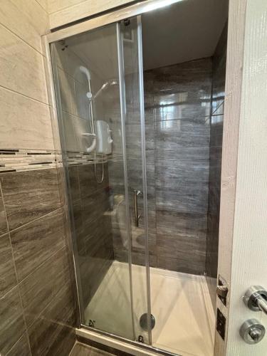 una ducha con puerta de cristal en un baño en Modern Studio - Central Location - Parking & Wi-Fi, en Bolton