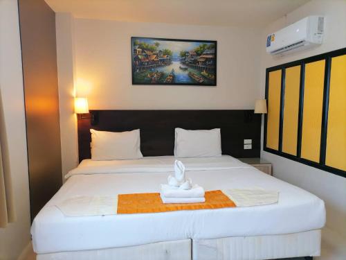 a hotel room with a bed with a statue on it at AtWhitePatong in Patong Beach