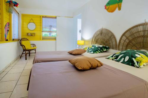 a room with two beds with pillows on them at L'Or des Caraibes in Sainte-Anne