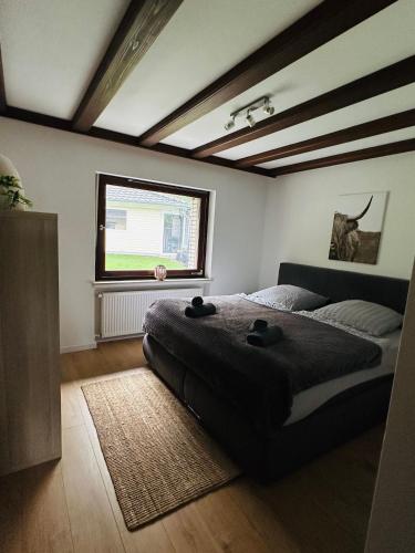 ein Schlafzimmer mit einem großen Bett und einem Fenster in der Unterkunft Villa Eifelblick Sauna&Wellness Apartment in Heimbach