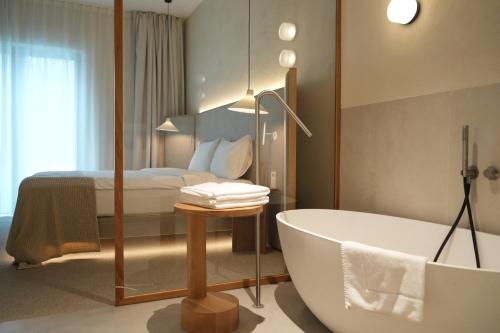 ein Bad mit einer Badewanne und einem Bett in der Unterkunft At Hotel 35 in Słupca