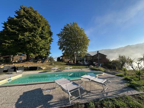 una piscina con 2 sillas de césped y adozen en Ca Jurzot, en Gorzegno