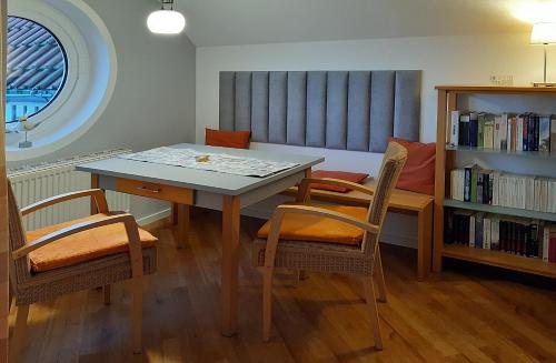 a dining room with a table and chairs and a book shelf at Ferienwohnung Seeblick 222 in Koserow